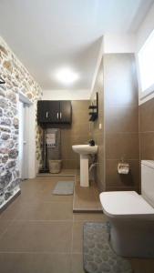 een badkamer met een wit toilet en een wastafel bij Markos House in Kalymnos