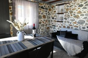 tavolo da pranzo con bottiglia di vino e bicchiere di vino di Markos House a Calimno (Kalymnos)