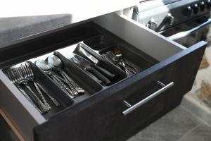 un cassetto nero con utensili dentro in una cucina di Markos House a Calimno (Kalymnos) Altre 9 foto