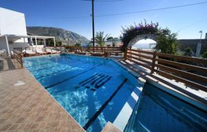 een groot zwembad met een houten hek bij Markos House in Kalymnos
