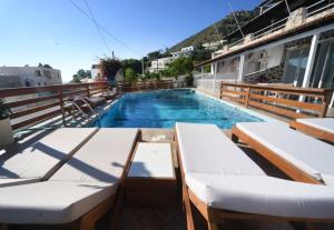 een zwembad met twee ligstoelen naast een gebouw bij Markos House in Kalymnos +9 foto's