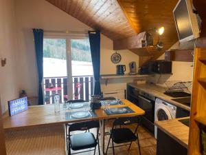 a kitchen with a table and chairs in a kitchen at Studio Belle Neige in Bernex