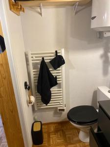 a small bathroom with a toilet and a black seat at Studio Belle Neige in Bernex