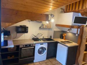 a kitchen with a washing machine and a washer at Studio Belle Neige in Bernex +9 photos
