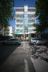 two cars parked in a parking lot in front of a building at Hotel Derby in Riccione