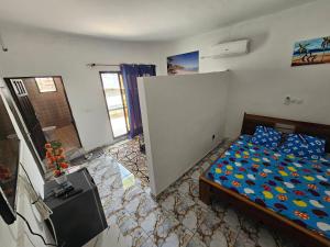a bedroom with a bed and a door in it at appartement avec balcon à Port Bouet cité SiPiM aéroport in Abidjan