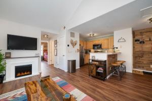 a living room with a fireplace and a kitchen at Waterside West A303 in Fraser