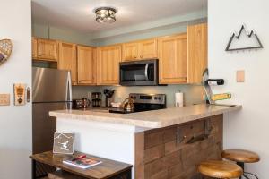a kitchen with wooden cabinets and a stainless steel refrigerator at Waterside West A303 in Fraser
