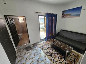 a living room with a couch and a door to a bathroom at appartement avec balcon à Port Bouet cité SiPiM aéroport in Abidjan