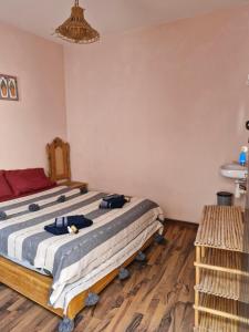 ein Schlafzimmer mit einem Bett und einem Holzboden in der Unterkunft le grand atlas in Mirleft