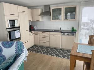 a kitchen with white cabinets and a sink and a table at Apartment Hälmli by Interhome in Heiden