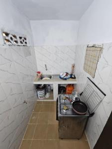 a small kitchen with a stove and a sink at appartement avec balcon à Port Bouet cité SiPiM aéroport in Abidjan