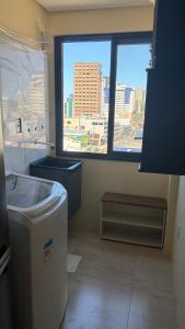 La salle de bains est pourvue d'une fenêtre offrant une vue sur la ville. dans l'établissement Apto torres, à Torres