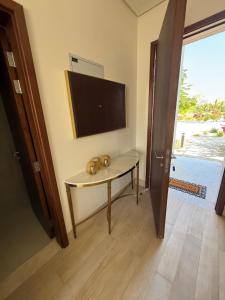 a room with a table with a flat screen tv at Villa Laguna Lux TU10 in Salalah