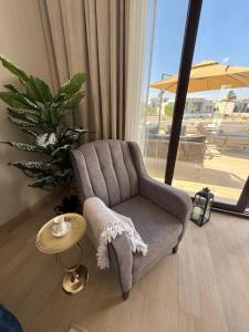 a living room with a chair and a table at Villa Laguna Lux TU10 in Salalah