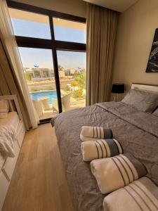a bedroom with a bed and a view of a pool at Villa Laguna Lux TU10 in Salalah