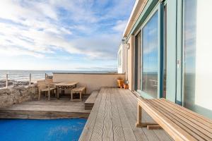 a wooden deck with a table and chairs and the ocean at Main Street No 56 - Lower Largo in Lower Largo
