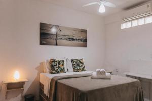 een witte slaapkamer met een bed met een deken bij Che Lagarto Hostel Itacaré in Itacaré