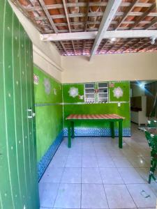 een kamer met een groene muur met een bank erin bij Casa Meu Aconchego in Fortaleza