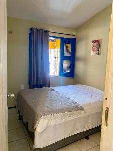 een slaapkamer met een groot bed en een raam bij Casa Meu Aconchego in Fortaleza