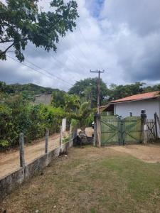 una recinzione con un cancello verde di fronte a una casa di Sítio Guanabara a Guaramiranga