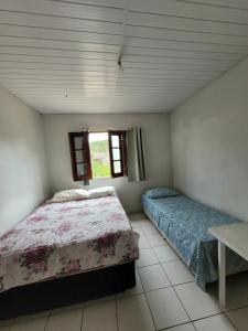 una camera da letto con due letti e una finestra di Sítio Guanabara a Guaramiranga