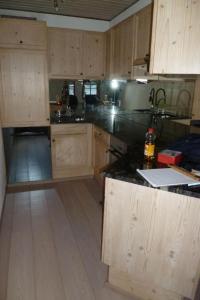 a kitchen with wooden cabinets and a black counter top at Apartment Chesa Blais by Interhome in Zuoz