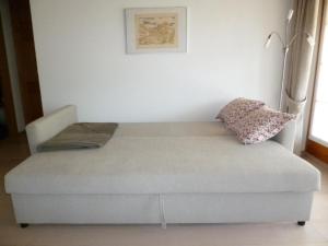 a couch in a living room with a pillow on it at Apartment Chesa Blais by Interhome in Zuoz