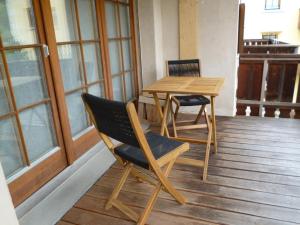 a wooden table and chairs sitting on a porch at Apartment Chesa Blais by Interhome in Zuoz +10 photos