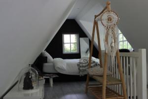 a bedroom with a bed and a chair in a attic at Forest Inn in Ugchelen