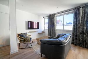 a living room with a couch and a window at Le boudoir du Palais in Périgueux