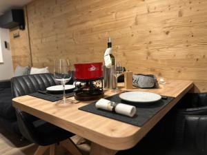 ein Holztisch mit zwei Gläsern und einer Flasche Wein in der Unterkunft Tiny House IBEX in Saas-Fee + 42 Fotos