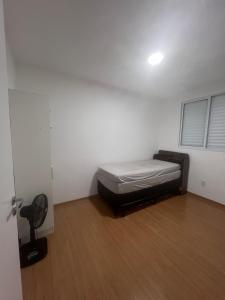 una stanza con un letto e una sedia di Apartamento proximo centro a Poços de Caldas