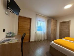 a bedroom with a bed and a desk and a television at Rifugio Capanna Bill in Rocca Pietore