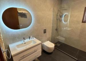 Un baño con lavabo, inodoro y espejo. en Villa Rosa Luxury Boutique Hotel, en Batroun