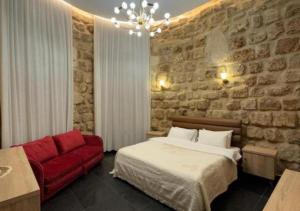 Un dormitorio con una cama y un sofá rojo. en Villa Rosa Luxury Boutique Hotel, en Batroun