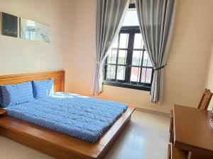 a bedroom with a blue bed and a window at Khách Sạn Đối Ngoại Biên Phòng in Buon Ma Thuot +30 photos