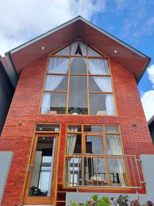 ein großes Fenster an der Seite eines Backsteingebäudes in der Unterkunft Carika Cabin in Diyeng