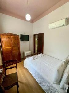 a bedroom with a white bed and a television at Hotel Lenheiros in São João del Rei +57 photos