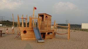 a wooden playground with a slide on a beach at Beach Hotel & Lodges Oostvoorne in Oostvoorne