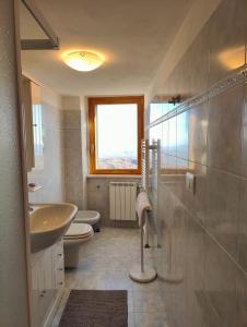 un bagno con lavandino, WC e finestra di Casa Viola della Maiella a Pennapiedimonte Altre 19 foto