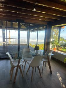 een eetkamer met een glazen tafel en stoelen bij San Vicente Mountain in Colón