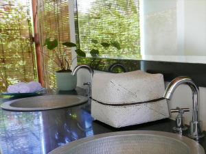 a kitchen counter with two sinks and a window at Villa Bahagia in Nusa Lembongan