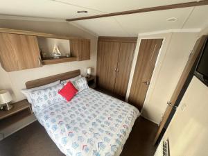 a small bedroom with a bed with a red pillow at The Pilot s Rest sleeps 6 in Exmouth
