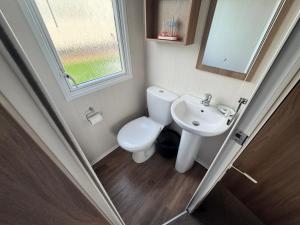 a small bathroom with a toilet and a sink at The Pilot s Rest sleeps 6 in Exmouth +5 photos