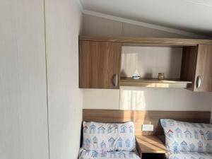 a bedroom with a bed and a cupboard and two pillows at The Pilot s Rest sleeps 6 in Exmouth