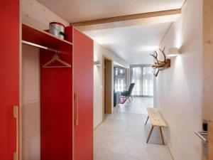 a hallway with a red door in a house at Apartment Bellezza - Bio Bergün by Interhome in Bergün
