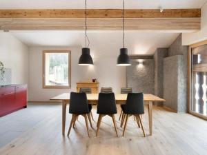 a dining room with a wooden table and black chairs at Apartment Bellezza - Bio Bergün by Interhome in Bergün +12 photos