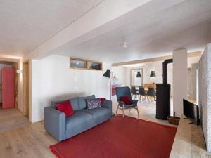 a living room with a blue couch and a red rug at Apartment Bellezza - Bio Bergün by Interhome in Bergün