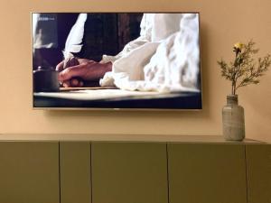 a television on a wall with a picture of a chef at Apartment Mountain 4U by Interhome in Meiringen